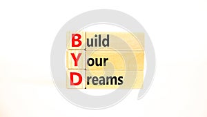 BYD build your dreams symbol. Concept words BYD build your dreams on wooden blocks on a beautiful white table white background.