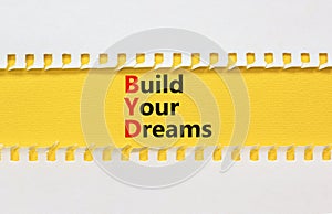 BYD build your dreams symbol. Concept words BYD build your dreams on yellow paper on a beautiful white paper background. Business
