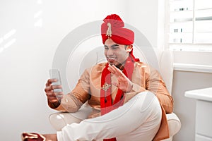 Bye bye bachelorhood, hello happily ever after. a young man waving while using a smartphone on his wedding day. photo