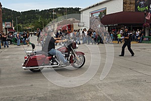 A byker riding his chopper motorcycle during the annual Sturgis Motorcycle rally in the main street of the city of Sturgis