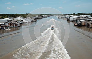 Ca Mau riverside residential with motor boat