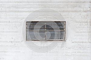 Barred window in the middle of a white wall photo