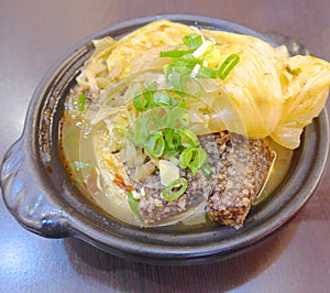 Cabbage clay pot with black rice cakes closeup