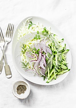 Cabbage, cucumber, red onion, greek yogurt, coleslaw salad on white background, top view. Detox diet food