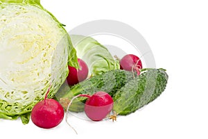 Cabbage cut in half closeup, two cucumbers and red radish