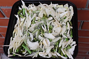 The cabbage with green beans in the pan before stewing