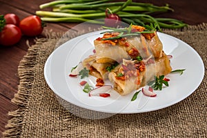 Cabbage rolls in tomato sauce. white plate. wood background.