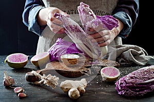 Cabbage and watermelon radish kimchi ingredients. Woman salting purple cabbage for kimchi. Fermented probiotic food for gut health