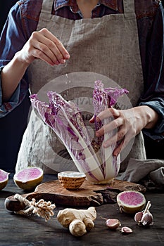 Cabbage and watermelon radish kimchi ingredients. Woman salting purple cabbage for kimchi. Fermented probiotic food for gut health photo