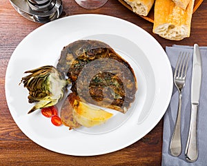 Cabeza de cordero - spanish dish. Lamb head with artichoke, tomatoes and potatoes photo