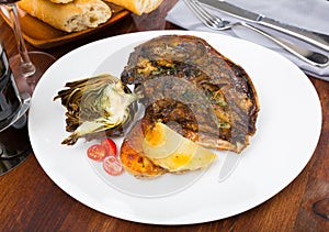 Cabeza de cordero - spanish dish. Lamb head with artichoke, tomatoes and potatoes photo