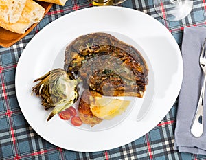 Cabeza de cordero - spanish dish. Lamb head with artichoke, tomatoes and potatoes photo