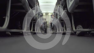 Cabin airplane with passengers sitting on seats and stewardess walking aisle while flying. Passengers on seat in economy