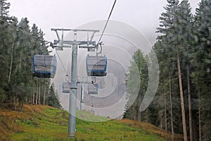 Cabin of Cable car lift arrive to top of the mountain with place of rest, restaurant and hotel in foggy day. Dolomites, Italy.