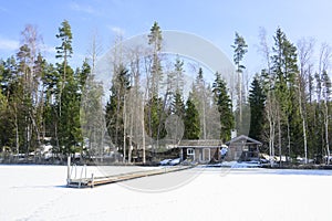 Cabin and cottages at the edge of a frozen lake in Finland.