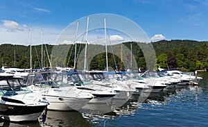 Cabin cruiser boats in a row on a lake with beautiful blue sky in summer