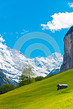 Cabin on green mountain slope. Swiss Alps landscape. Lauterbrunnen, Switzerland, Europe.