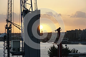 Cabin of mobile crane operated by stevedores during cargo operation in Nassau in time of sunrise.