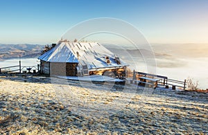 Cabin in the mountains in winter. Mysterious fog. In anticipatio