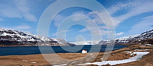 Cabin near lake and snowcapped westfjords icelandic mountains