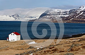 Cabin near lake and snowcapped westfjords icelandic mountains