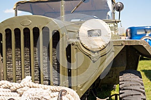 Cabin of old military truck with camouflaged headlight.