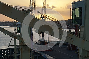 Cabin of ship crane of container vessel during cargo operation in Nassau in time of sunrise.