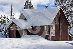 Cabin With Snow Piled Up On Roof