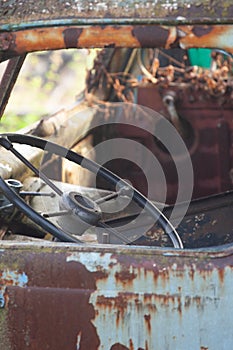 The cabin and the steering wheel of an old abandoned and rusty truck