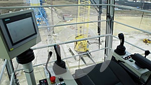 Cabin to control the crane. View from the crane operator working place. Gantry crane operator moving a sea container