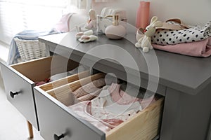 Cabinet drawers with baby clothes in child room