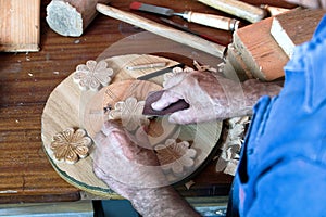 Cabinetmaker's hands using sandpaper on a piece of wood