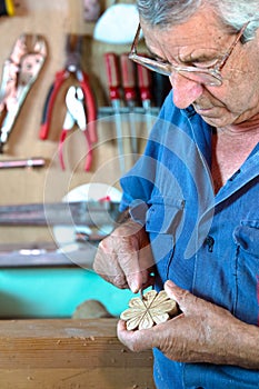 Cabinetmaker sanding a decorative piece of wood