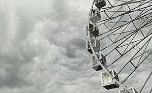 Cabins of a big ferris wheel over dark stormy cloudy sky