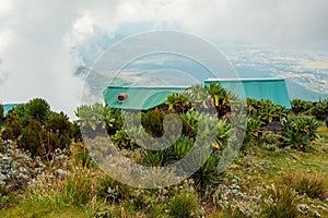 Cabins in Mountains against Mount Muhabura in the Mgahinga Gorilla National Park, Uganda