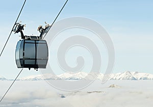 Cable car cabin going up above the clouds to the very top of a mountain at a ski resort