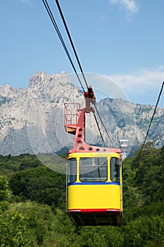 Cable car cabin on a mountain background. The rise of the cable car to the mountains in the summer