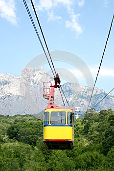 Cable car cabin on a mountain background. The rise of the cable car to the mountains in the summer