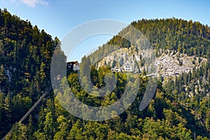 Cable car, forest and mountains over the Austrian city of Hallstatt, under a blue sky