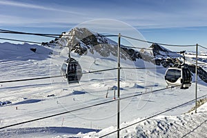 Cable car in the mountains and white snowy ski slopes. Snowy winter mountain background.