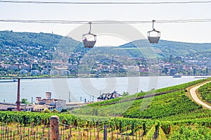 Cable car on rope of cableway from Rudesheim am Rhein town to Roseneck mount above vineyards fields