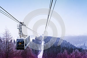 Cable car traveling on ropeway through a beautiful woodland landscape in Zao Skii resort