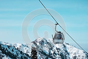 Cable car way on snowy mountains background.