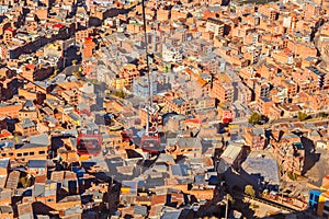 Cable cars or funicular system over orange roofs and buildings of the Bolivian capital, La Paz, Bolivia