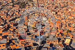 Cable cars or funicular system over orange roofs and buildings of the Bolivian capital, La Paz, Bolivia