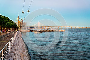 The cable cars overlook the Vasco da Gama bridge on the Tagus river.