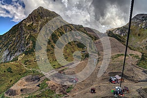 Cable chair ski lift in Gorky Gorod mountain ski resort in Caucasus mountains on Aibga peak background. Scenic autumn landscape of