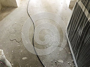 Cable on the dirty floor. Material for repairs in an apartment is under construction remodeling rebuilding and renovation