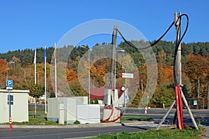 The cable of high-voltage electric power transmission line is fixed on wooden poles above the road.