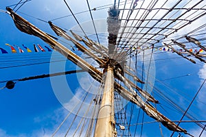 Cable ladders, mast and ropes of a sailing ship against the blue sky. Concept of travel, adventure and sea.